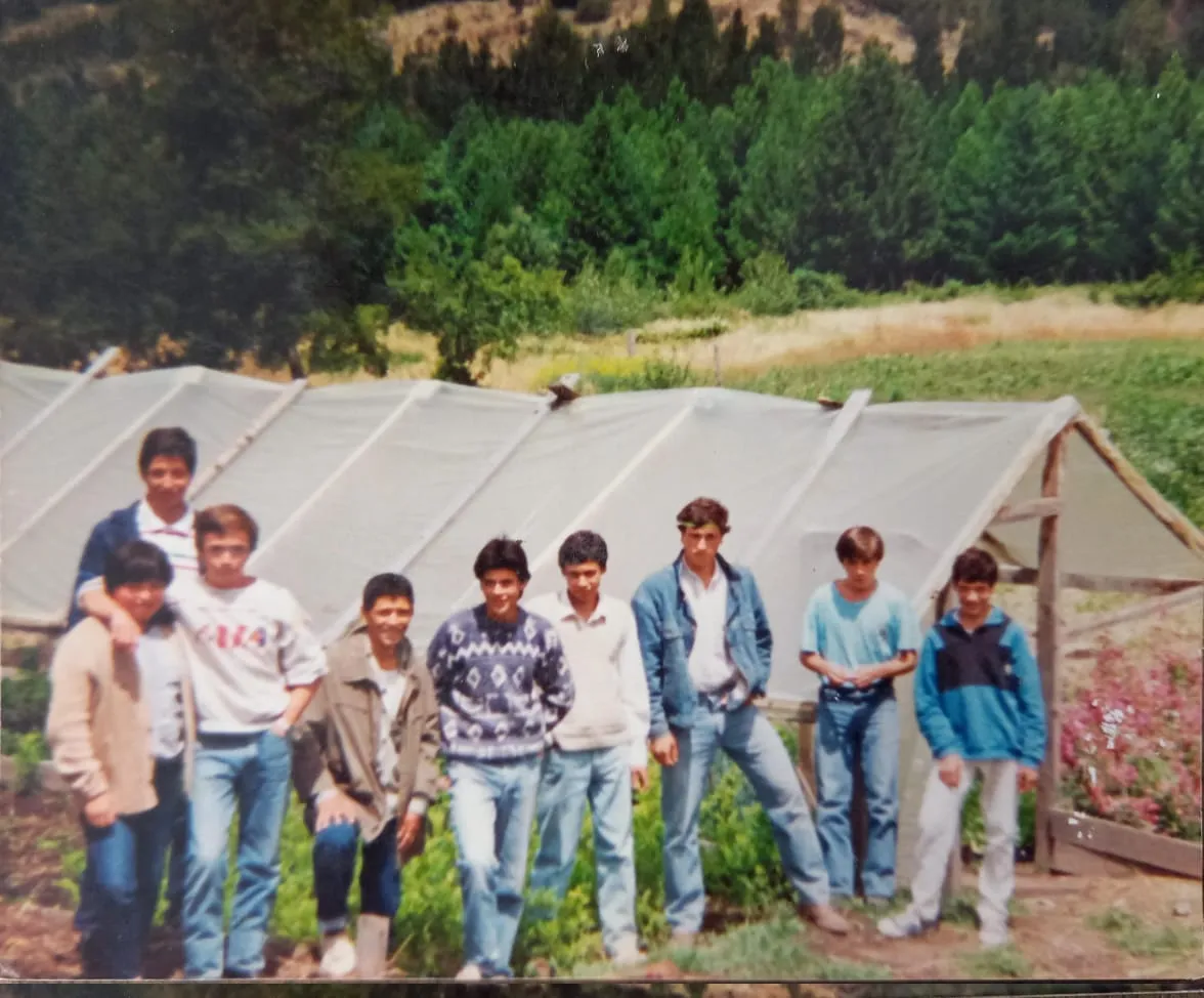 Estudiantes y profesor posando enfrente de un invernadero